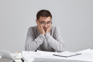 Puzzled man with glasses looking over notes